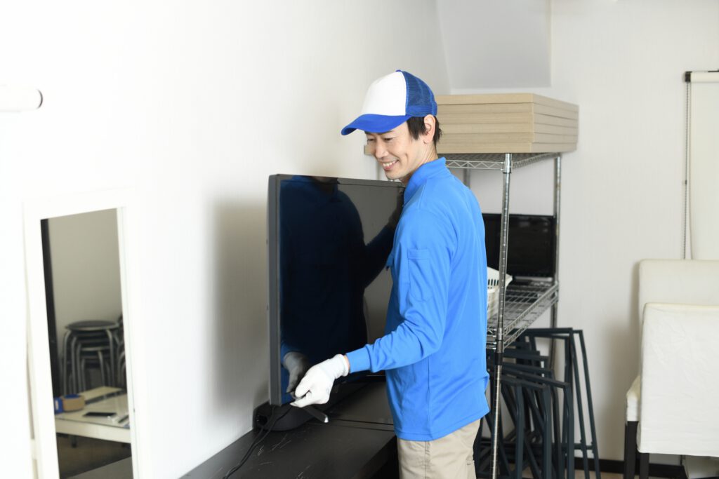 作業員がテレビを運ぶ
