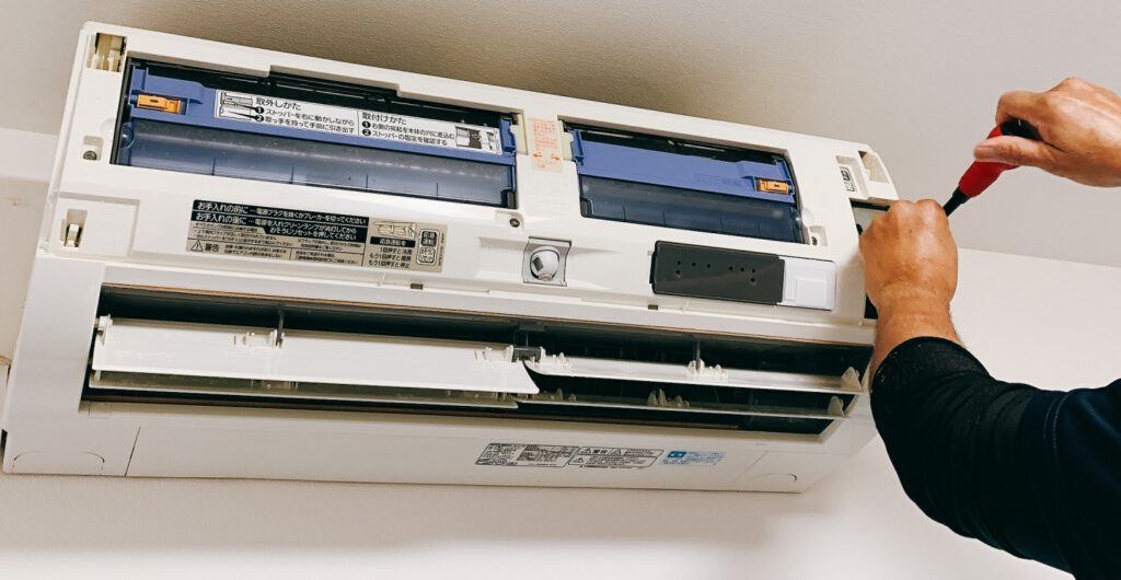 エアコンを点検する作業員