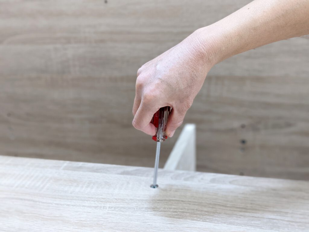 ドライバーで組み立て家具のネジを締める
