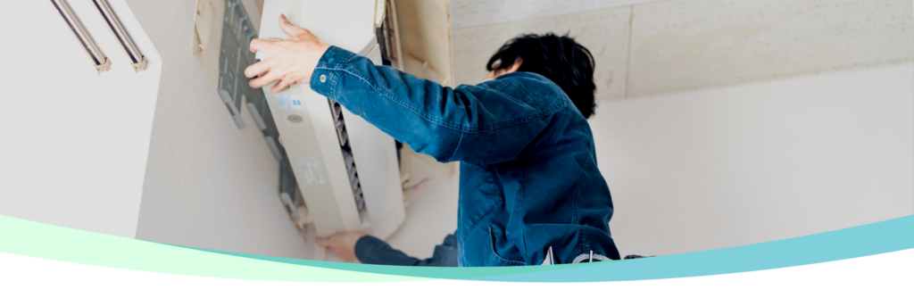 エアコンの取り外しを行う作業員